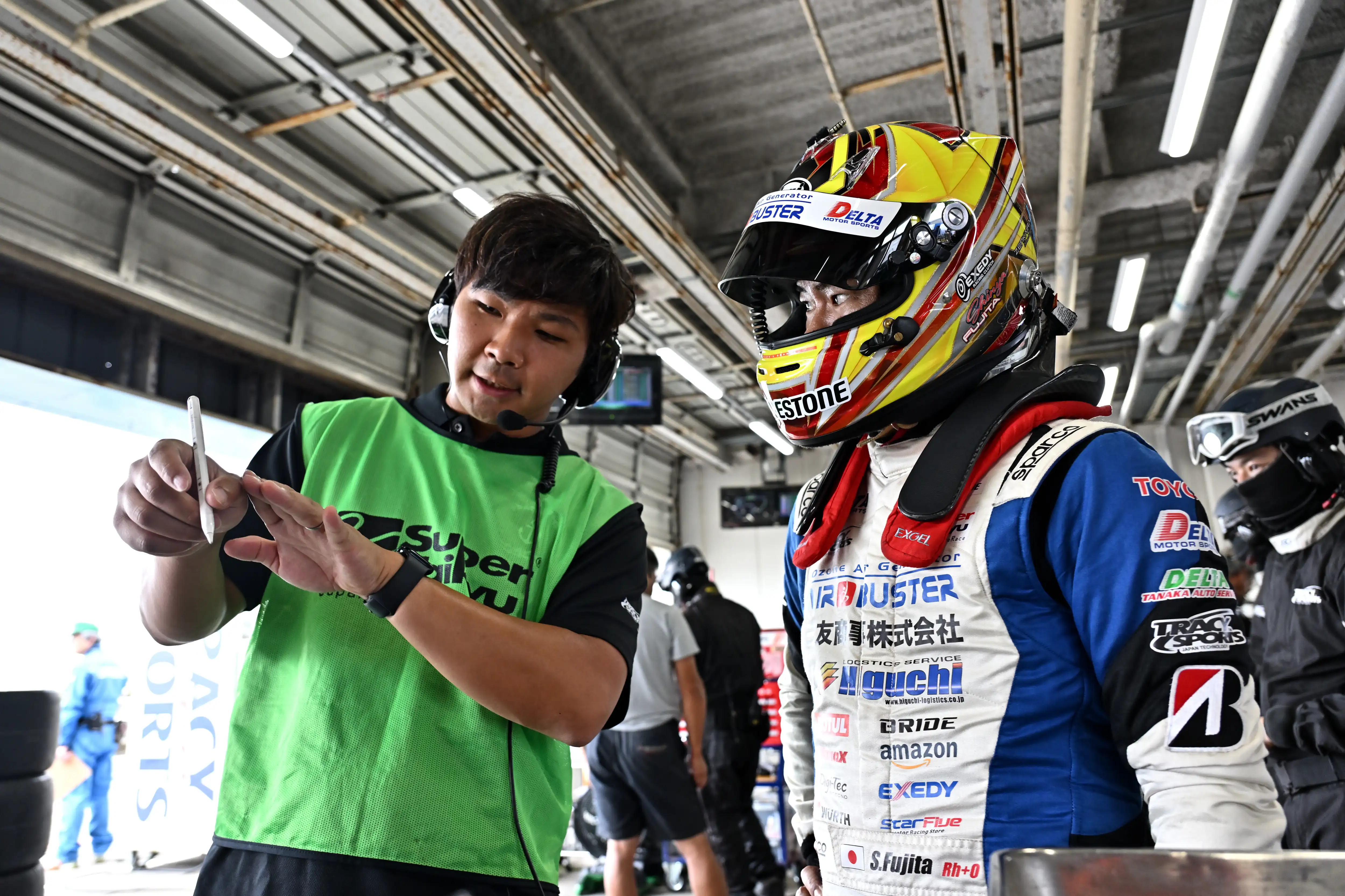 ピットでドライバーと打ち合わせをするスタッフ
